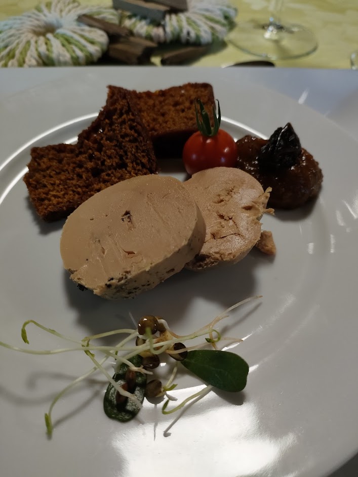 une assiette de foie gras avec une tranche de pain d'épices et une confiture de citrouille et de pruneaux