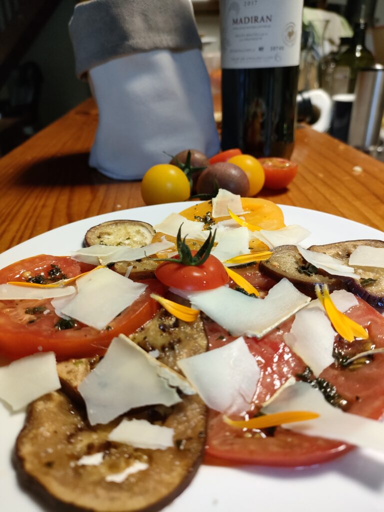 un carpacchio de tomate et d'aubergine avec des copeaux de fromage