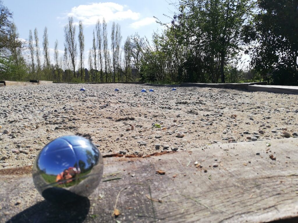 une boule de pétanque sur le bord en bois d'un terrain de pétanque dans la nature
