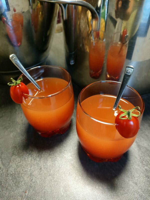 deux verres de jus de tomate avec une tomate cerise sur le bord